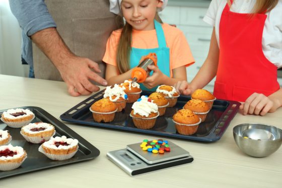 Children and teacher preparing dessert