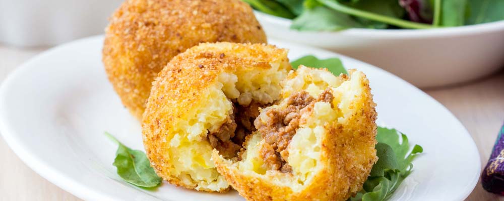 Italian appetizer arancini, rice balls stuffed with meat cooked in deep fat