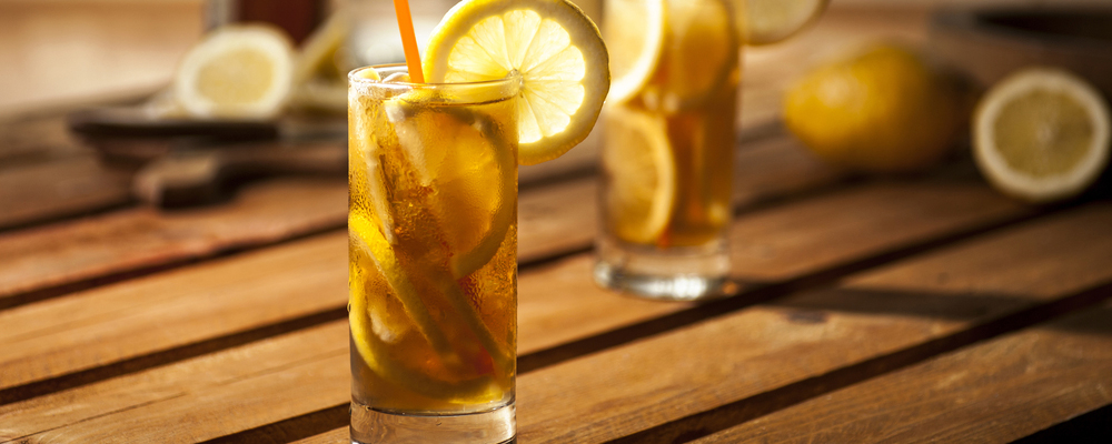 Long island ice tea coctails on wooden and white background.