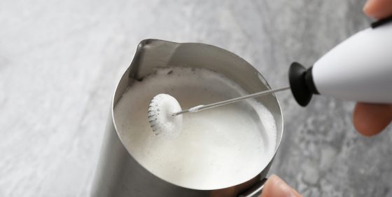 Woman using milk frother