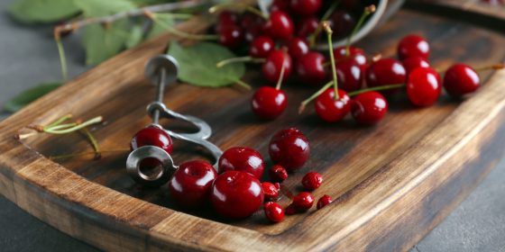 Wooden board with ripe cherries