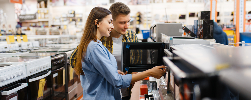 Couple choosing microwave in electronics store
