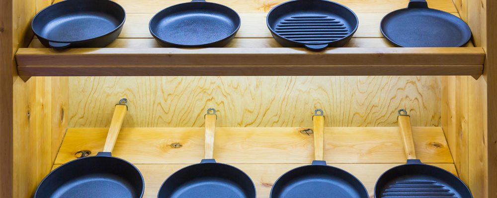 Frying pans on wooden shelf, cooking tools