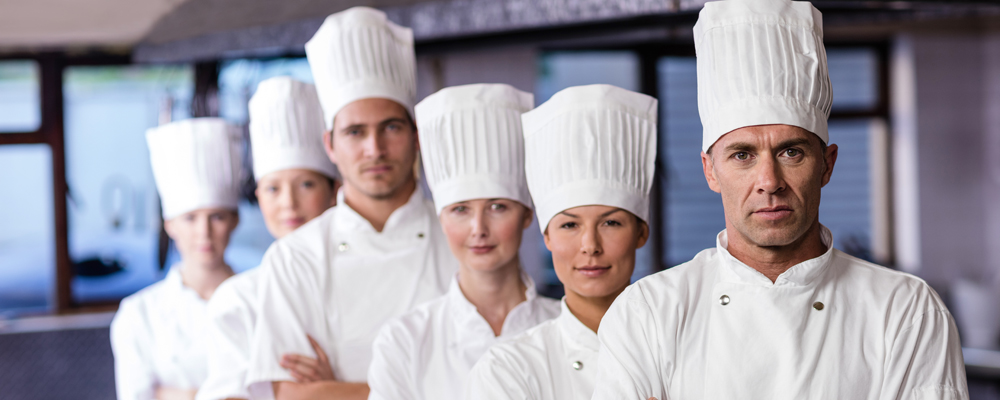 Group of chefs standing in kitchen