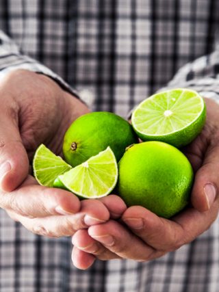 Limes on person's hand