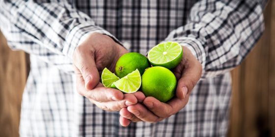 Limes on person's hand