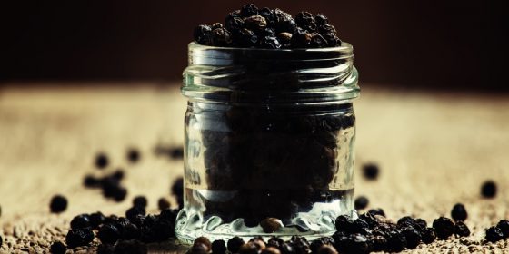 Pea of black pepper in a glass jar
