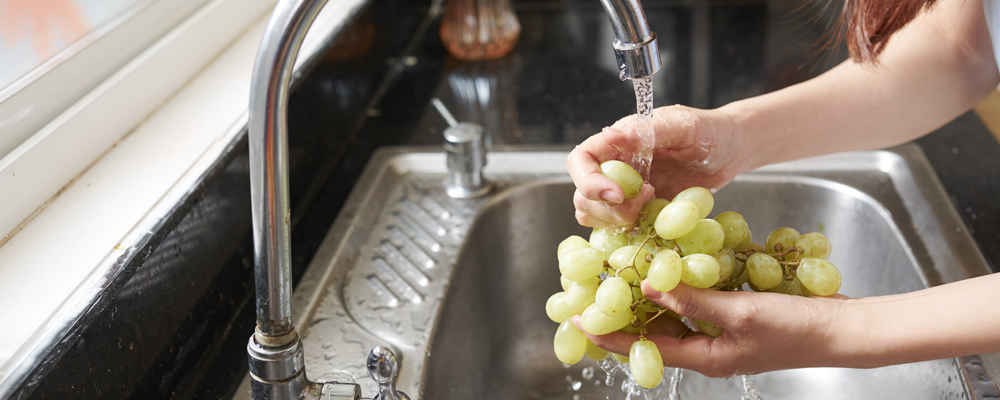 Woman rinsing organic grape