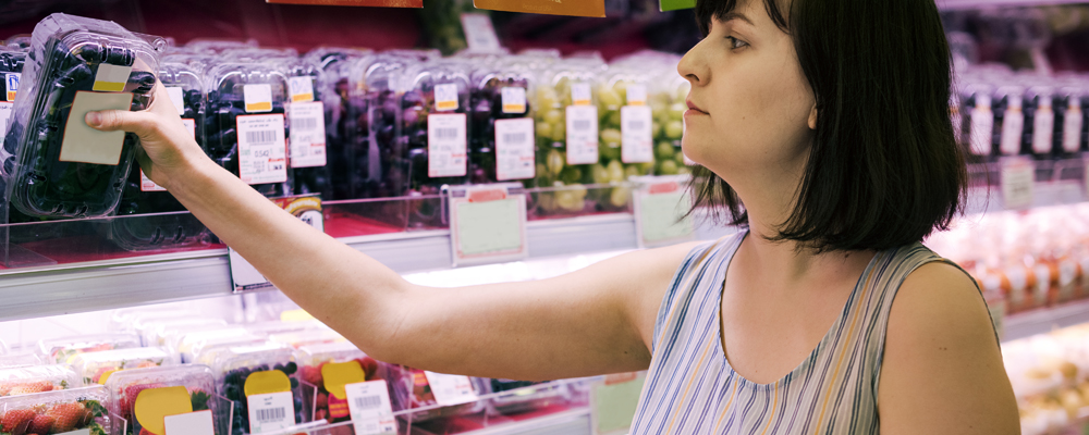 Woman selecting some grapes at the supermarket