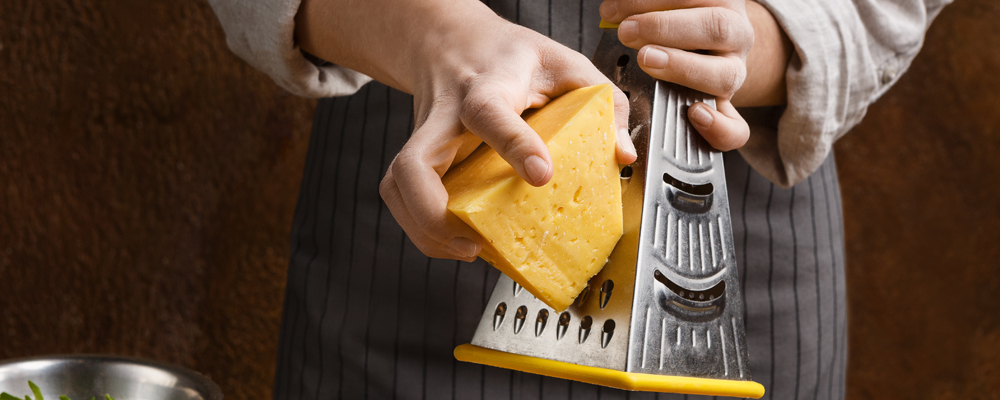 Woman sprinkling pizza with cheese